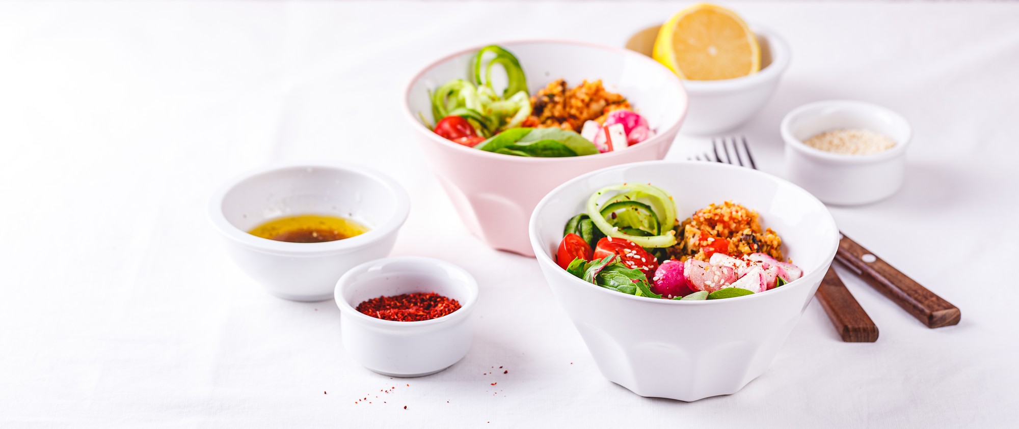 Stacked bowls with vibrant salad and dressing